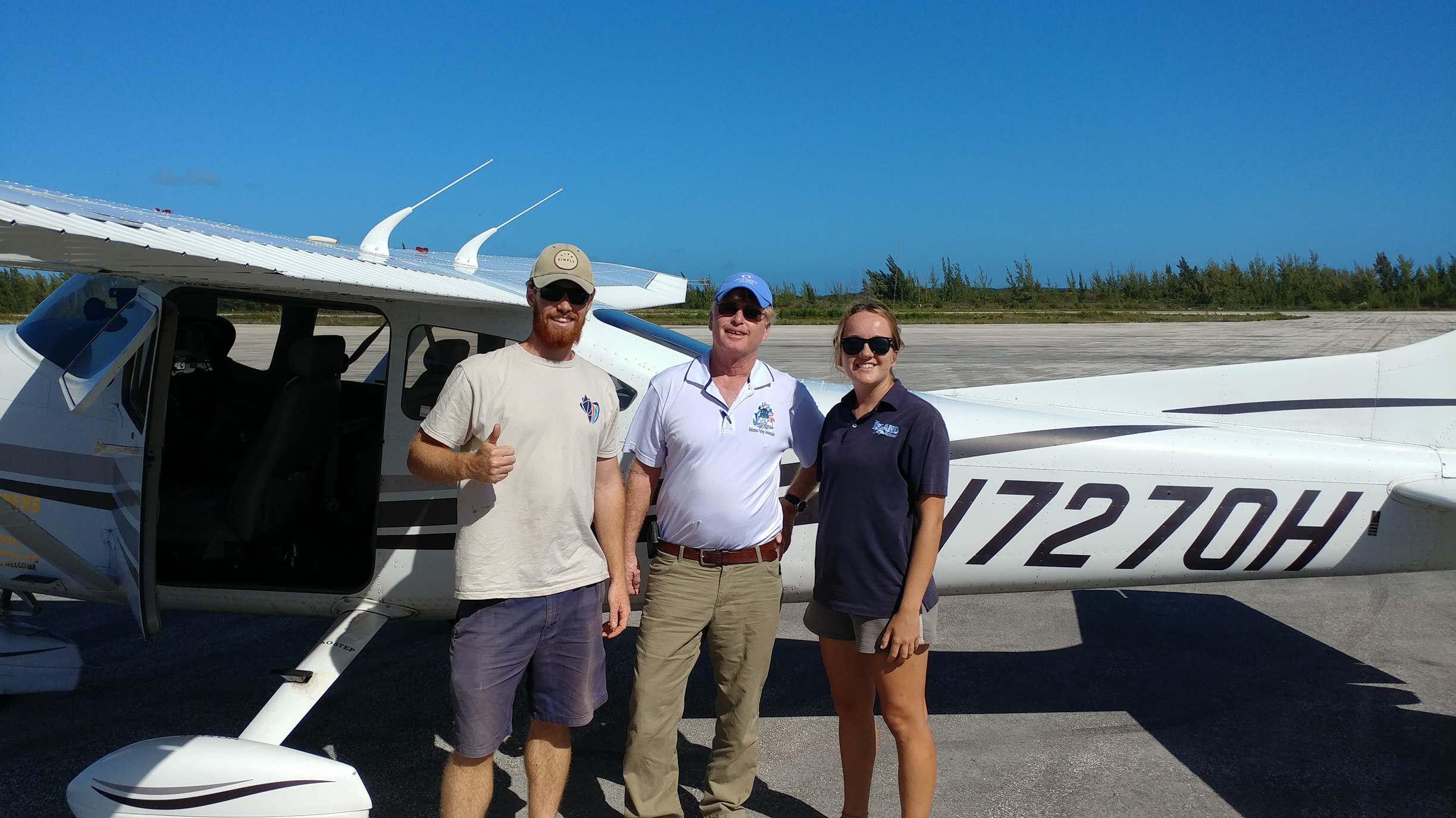 CEI researchers Eric Schneider (left) and Danielle Orrell (right) waving off Mark M. Steinberg (middle, pilot) transporting the samples to the US for analysis.