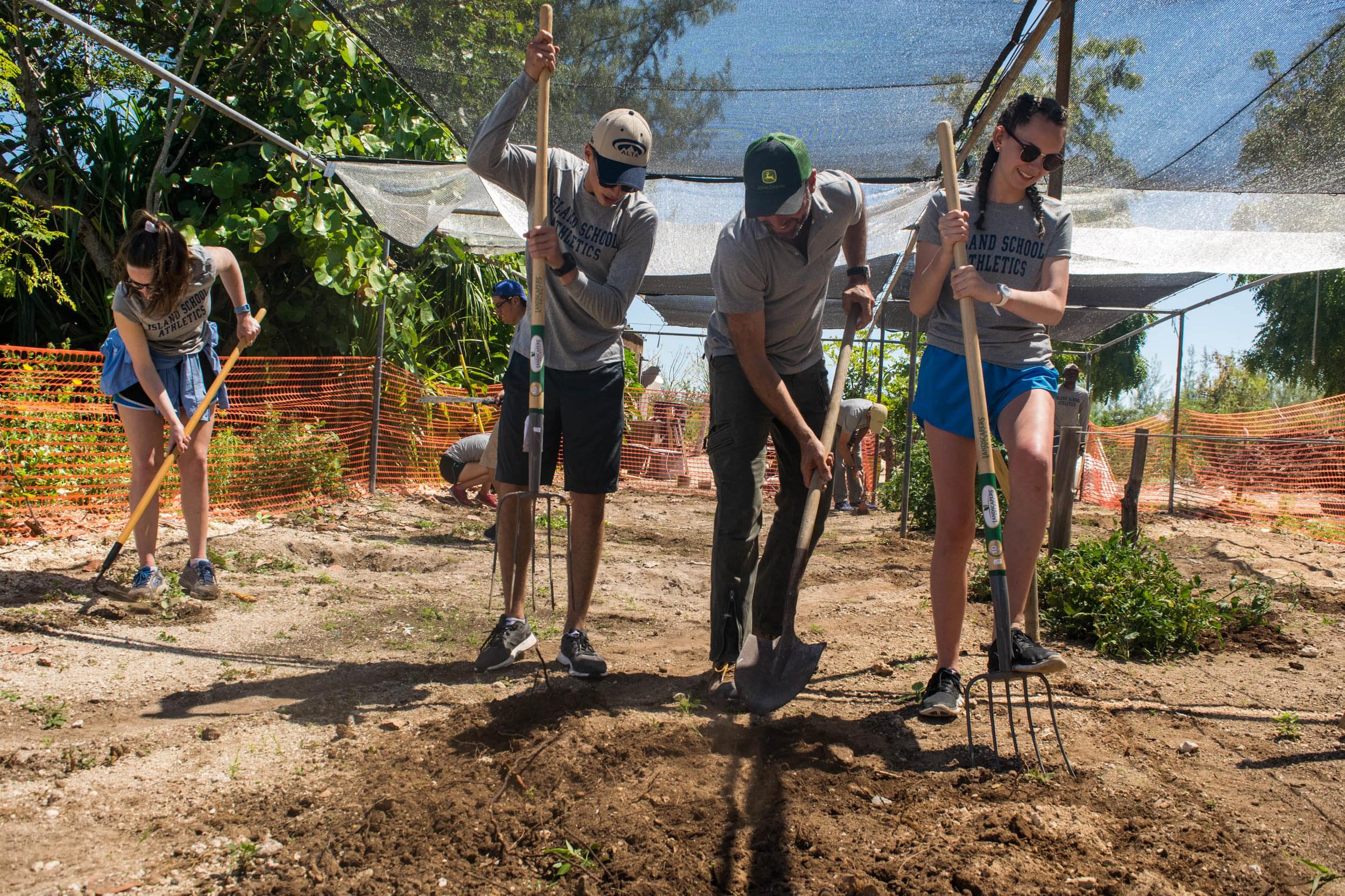 Teamwork makes the dream work! Students aerate the soil to prepare the new grow beds.